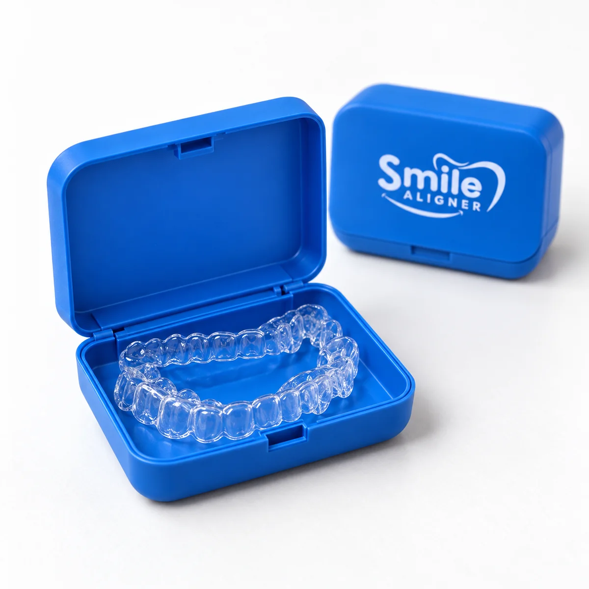 Gros plan sur des aligneurs transparents dans une boîte bleue ouverte, devant une boîte Smile Aligner fermée